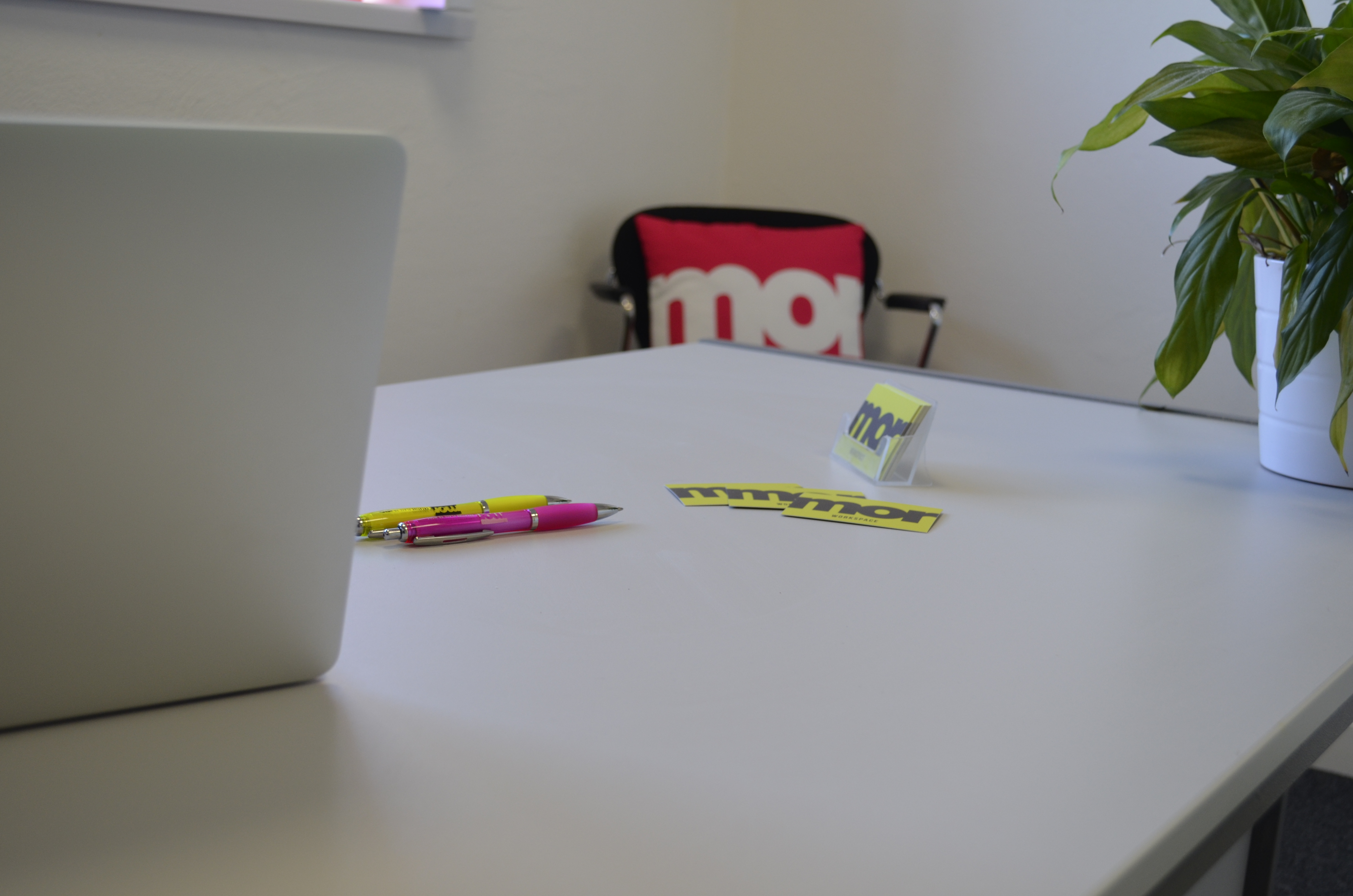 Desk with branded pens and company cards on